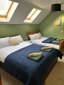 2 Betten in einem Schlafzimmer mit Oberlichtern in der Unterkunft Brady Accommodation in Monaghan