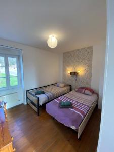 a bedroom with two beds and a window at Gîte les Herbiers in Les Herbiers +2 photos