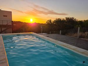 una piscina con il tramonto sullo sfondo di Hotel Playa Chihuahua a Punta del Este Altre 43 foto