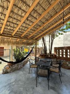 a patio with a table and chairs and a hammock at KAO Cabin in Brisas de Zicatela