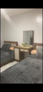a room with two beds and a desk with a computer at شقة خاصة in Cairo