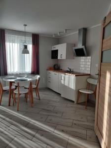 a kitchen and dining room with a table and chairs at Apartament Charlie in Darlowko