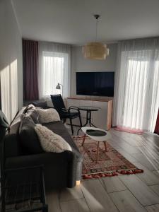 a living room with a couch and a table at Apartament Charlie in Darlowko