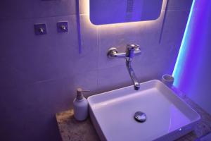 a bathroom with a sink and a bottle of soap at Galleria Home in Serres +47 photos