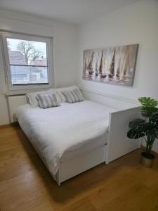 een wit bed in een kamer met een raam bij Grand Family Residence Ljubljana in Ljubljana +27 foto's