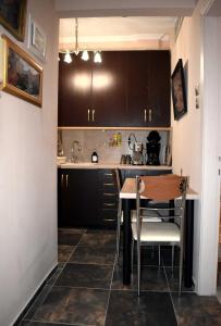 a kitchen with brown cabinets and a table and chairs at Galleria Home in Serres