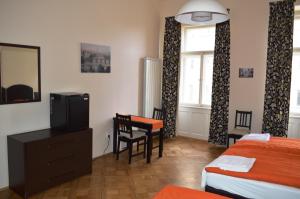 a room with a bed, television and a desk at Valentina Apartments in Prague