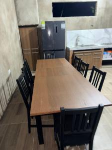 a kitchen with a wooden table with chairs and a refrigerator at Finca Campestre - Villa Esther con Piscina en Mesitas del Colegio in El Colegio