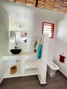 a bathroom with a sink and a toilet at Bungalow Maniry Andilana in Andilana +48 photos
