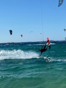a person in the air on a surfboard in the ocean at Villa Xanthos in Plaka