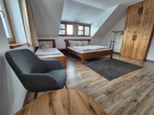 a room with a chair and a bed and a couch at Chata Marta in Boží Dar