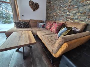 a living room with a couch and a brick wall at Chata Marta in Boží Dar