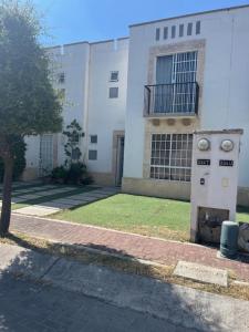 a large white building with a grass yard in front of it at Casa Completa Cómoda en el Sur in Santa Gertrudis