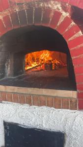 ein gemauerter Ofen mit Feuer im Inneren in der Unterkunft Villa Eddy in Perdifumo