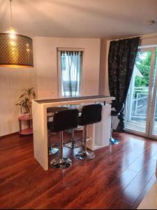 een keuken met een bar met 2 krukken bij Top Apartment in Langenhagen in Hannover