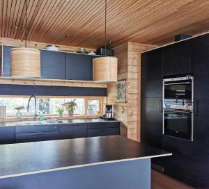 a kitchen with black cabinets and a black counter top at FjordView Sanctuary in Nedstrand +87 photos