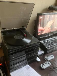 a desk with a laptop and a cd and a keyboard at Het werkhuis, terug in de tijd in Uden