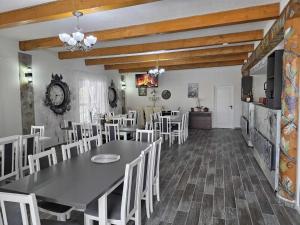 una sala da pranzo con un tavolo e sedie bianche di Cabana OAZA AMURG a Runcu Altre 49 foto