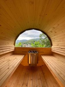 a sauna with a window and a trash can at Poncyljuszówka in Szczyrk