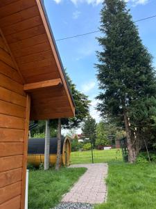 a wooden building with a tree and a fence at Poncyljuszówka in Szczyrk