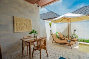 a patio with a table and an umbrella and chairs at Pondok loji villa in Ubud