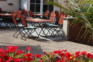 eine Gruppe von Stühlen und Tischen und Blumen auf einer Terrasse in der Unterkunft In Piazza in Bad Klosterlausnitz