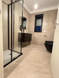 a bathroom with a glass shower and a toilet at LP House in Rovereto +17 photos