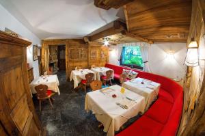 a restaurant with two tables and a red couch at Hotel Gran Baita in Gressoney-Saint-Jean
