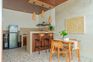 a kitchen with a table and chairs and a refrigerator at Pondok loji villa in Ubud