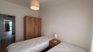 a bedroom with two beds and a wooden cabinet at Park Apartment - 2 Room APT in Lavradio