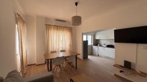 a living room with a dining room table and a kitchen at Park Apartment - 2 Room APT in Lavradio