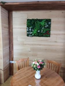 a table with a vase of flowers on it at Апартамент почивка в планината in Pamporovo