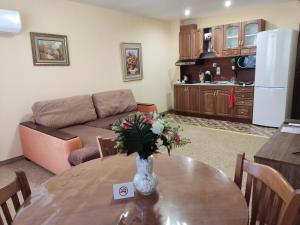 a living room with a table with a vase of flowers on it at Апартамент почивка в планината in Pamporovo