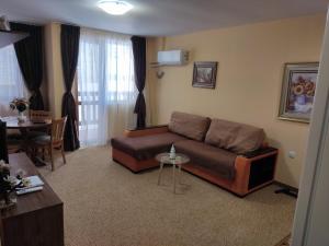 a living room with a couch and a table at Апартамент почивка в планината in Pamporovo