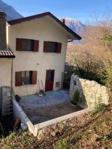 een wit huis met een rode deur en een tuin bij L'Intermezzo in Venzone