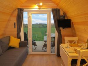 a living room with a couch and a sliding glass door at Rainbow View in Ellesmere