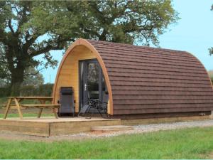 a large wooden cabin with a picnic table in front of a tree at Rainbow View in Ellesmere +20 photos