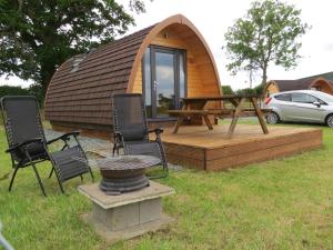 a round cabin with a table and chairs in front of it at Rainbow View in Ellesmere