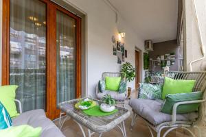 a porch with two chairs and a table with green pillows at Armea Suite Apartment in Trani
