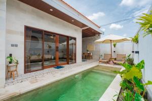 a villa with a swimming pool and a house at Pondok loji villa in Ubud