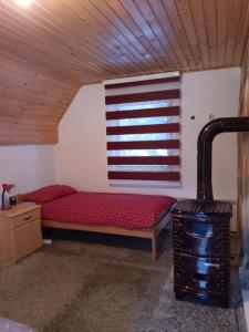 a room with a red bed and a window at Vikendica za odmor in Vlasic