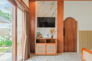 a living room with a television on a wall at Pondok loji villa in Ubud