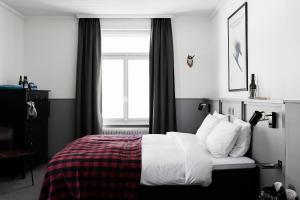 um quarto com uma cama com lençóis brancos e uma janela em Ski Lodge Engelberg em Engelberg