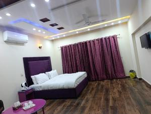 a bedroom with a bed and a purple curtain at Emporia Hotel & Suites in Lahore
