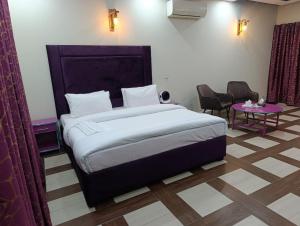 a bedroom with a large bed and a table at Emporia Hotel & Suites in Lahore +26 photos