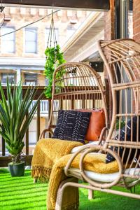 eine Veranda mit Rattanstuhl und Schaukel in der Unterkunft Jungle House Columbus Short North Downtown Free Parking - Steps to Convention Center & Nationwide Arena - 2BR Luxury Home - Sleeps 8 - Over 5,800 Five Star Stays in Columbus
