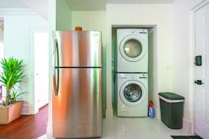 ein Kühlschrank und eine Waschmaschine in einem Zimmer in der Unterkunft Jungle House Columbus Short North Downtown Free Parking - Steps to Convention Center & Nationwide Arena - 2BR Luxury Home - Sleeps 8 - Over 5,800 Five Star Stays in Columbus