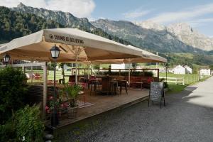 a restaurant with tables and chairs under a large umbrella at Ski Lodge Engelberg in Engelberg