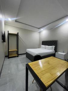 una stanza con un letto e un tavolo di Palms & Pebbles Lodge a Lilongwe