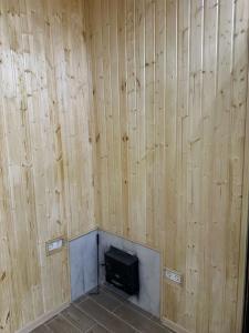 a room with wood paneled walls and a television at villacaptaingomi in Gomi